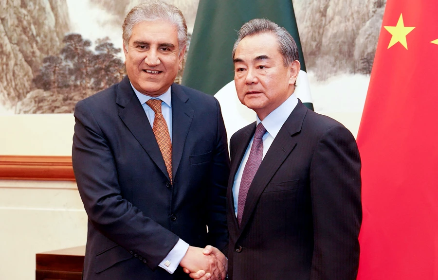 Chinese Foreign Minister Wang Yi (R) and Pakistani Foreign Minister Shah Mehmood Qureshi shake hands during their meeting in Beijing on Tuesday. (AFP)