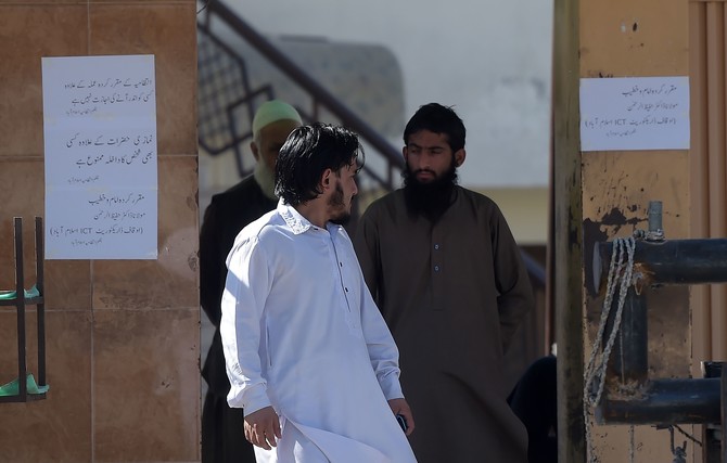 In this file photo, a worker of Jamaat-ud-Dawa (JuD) stands at the main entrance of a mosque belonging to the (JuD) in Islamabad on March 6, 2019. (AFP)