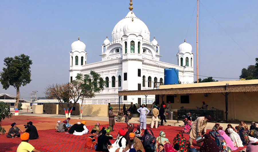 In this file photo, Sikh Pilgrims sit in front of Kartarpur Gurdwara Sahib before the groundbreaking ceremony of the Kartarpur Corridor. (AFP)