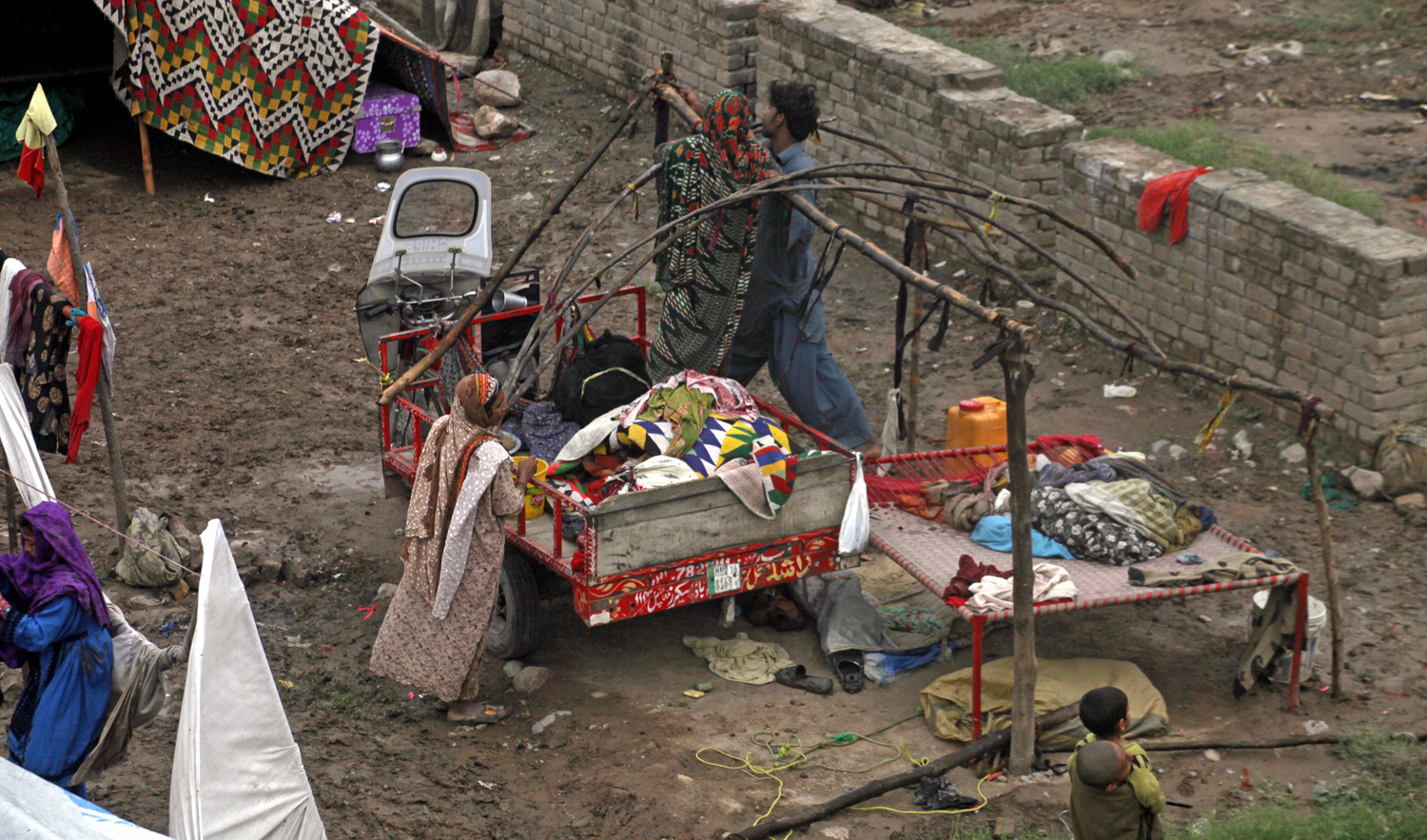 Members of Pakistani nomad community reelect their tent, uprooted by hailstorm and rains in suburbs of Peshawar, Pakistan, Wednesday, April 17, 2019. (AP)