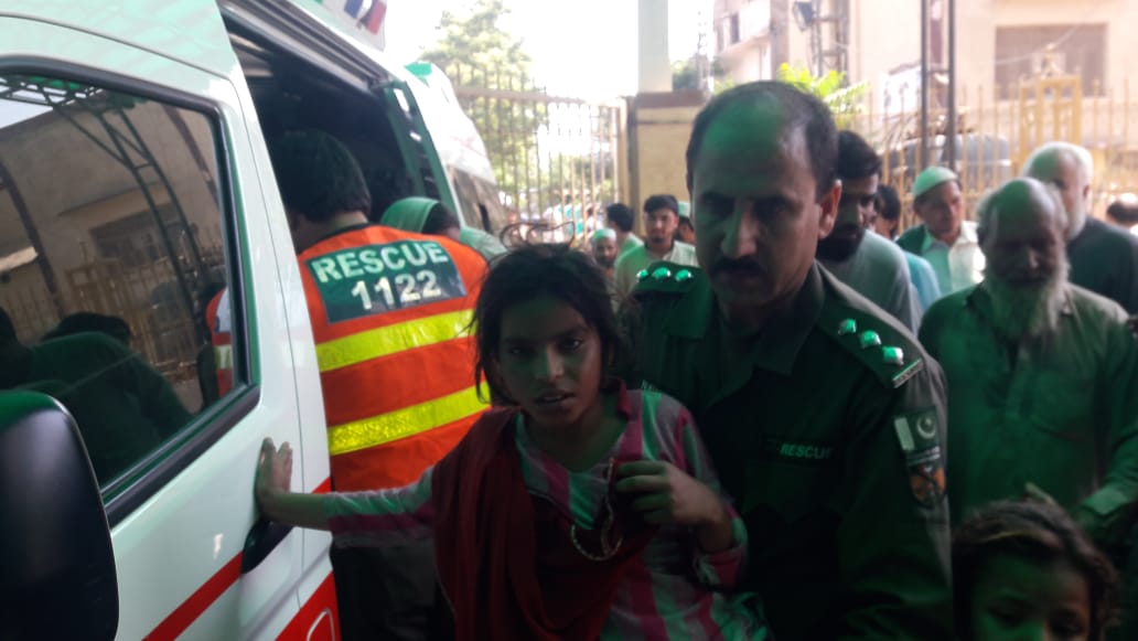 Rescue workers take a child to a nearby hospital in Peshawar on Monday. Many children complained of dizziness, vomiting and severe stomach ache after being administered anti-polio drops. (Ali Hamza)