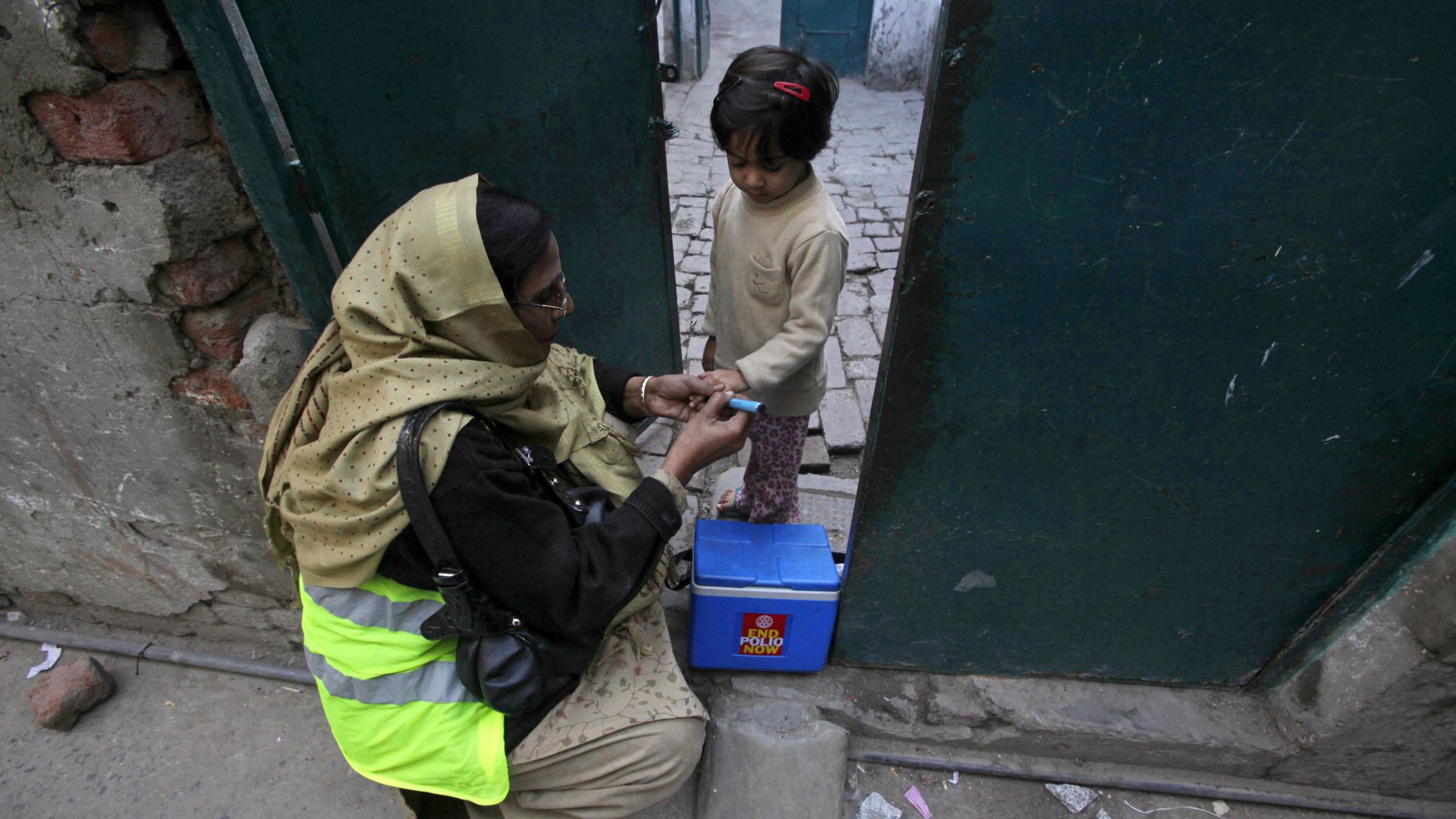 A female polio worker gives polio vaccine drops to a girl in Lahore December 20, 2012. (REUTERS)