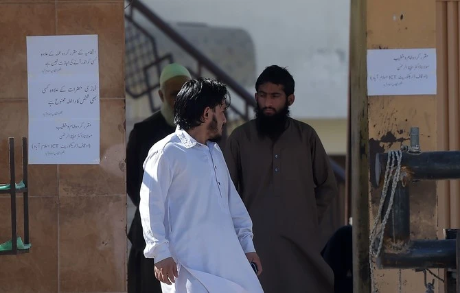 In this file photo, a worker of Jamaat-ud-Dawa (JuD) stands at the main entrance of a mosque belonging to the (JuD) in Islamabad on March 6, 2019. (AFP)