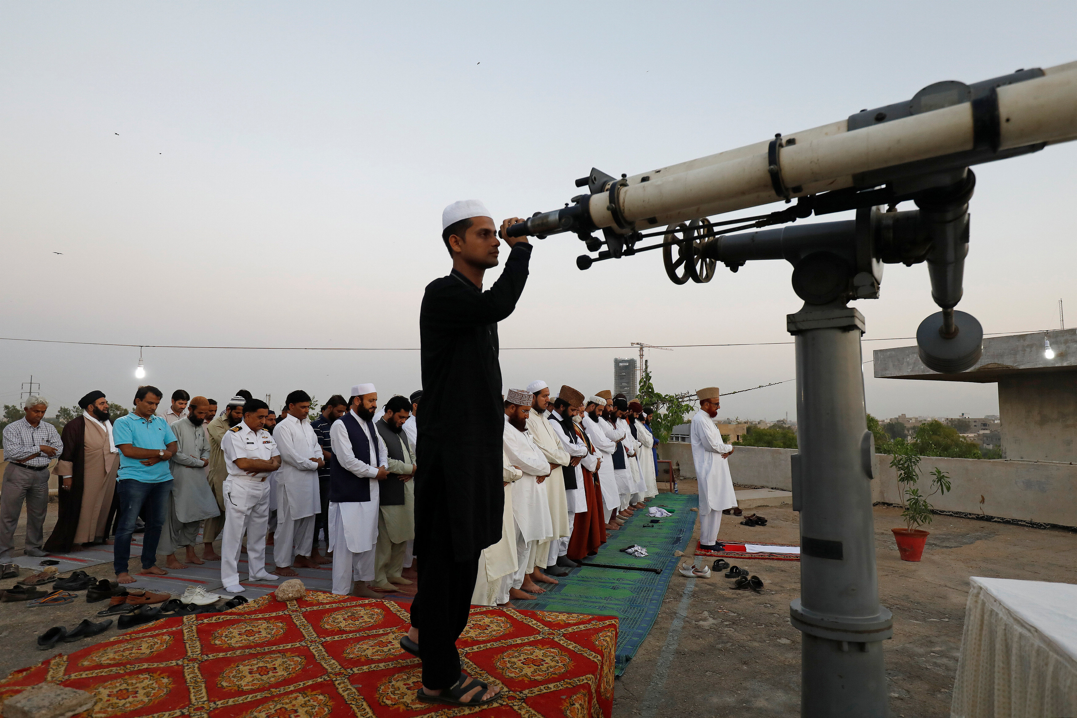 Members of Pakistan's moon sighting committee perform evening prayers after they tried to look for the new moon that will mark the start of the holy month of Ramadan, from Pakistan's Meteorological Department (PMD) building in Karachi, Pakistan May 5, 2019. (REUTERS)