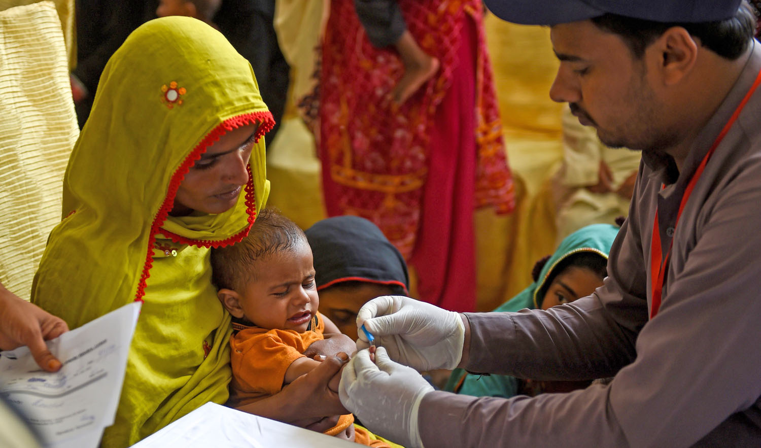 In this image taken on May 9, 2019, a Pakistani paramedic takes a blood sample from a baby for a HIV test at a state-run hospital in Rato Dero in the district of Larkana of the southern Sindh province. (AFP)