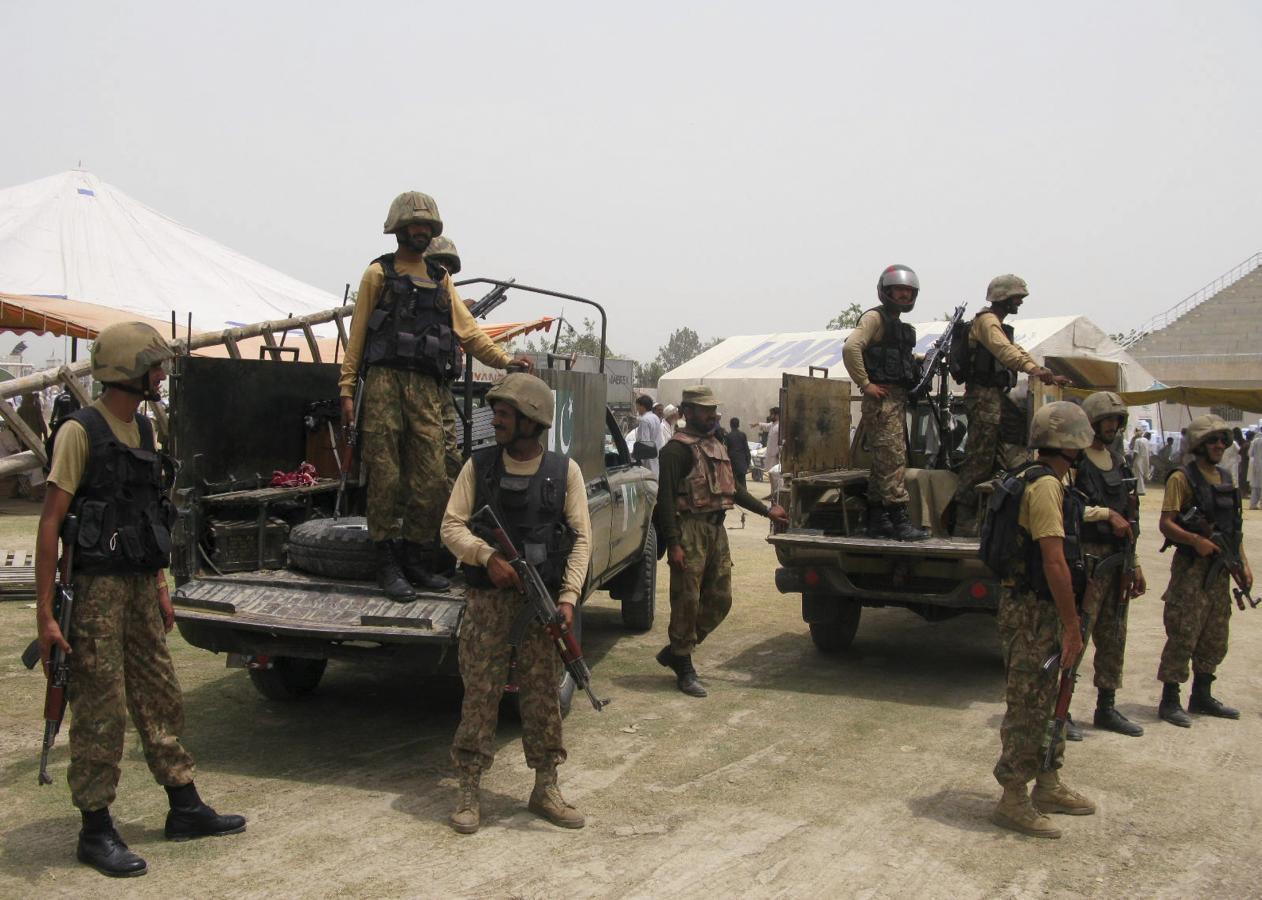 Pakistani soldiers stand guard as people, who fled the military offensive against militants in North Waziristan, receive food supply from the army in Bannu, in Pakistan's Khyber-Pakhtunkhwa province July 2, 2014. (REUTERS/FILE)