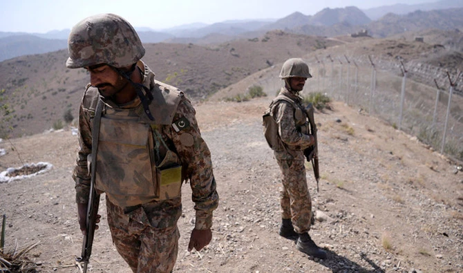In this file photo, Pakistani soldiers patrol next to a newly fenced border separating North Waziristan and Afghanistan. A roadside bomb has killed a soldier and wounded another three in the northwest along the Afghan border. (AFP/photo)