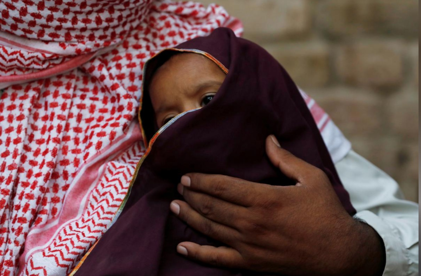 Two-year old HIV positive boy sits on the lap of his father, in Ratodero, Pakistan May 24, 2019. (Reuters)
