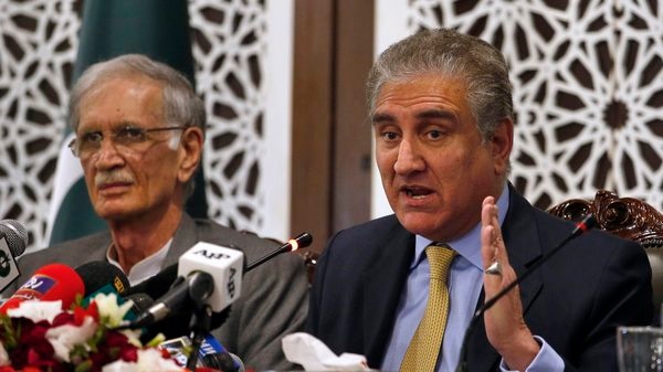 Pakistan’s Foreign Minister Shah Mahmood Qureshi (right) and Defense Minister Pervez Khattak address a press conference in Islamabad, following heightened tensions with India, in this file photo from February 26. (AP)