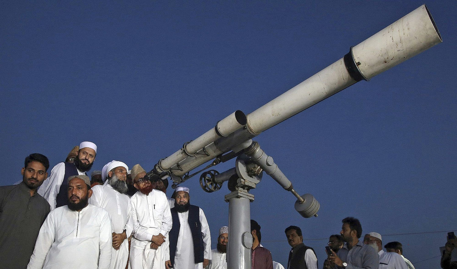 In this file photo, clerics of Pakistan’s Moon Sighting Committee search the sky with a telescope for the new moon that signals the start of the Muslim fasting month of Ramadan, in Karachi, May 5, 2019. (AP)