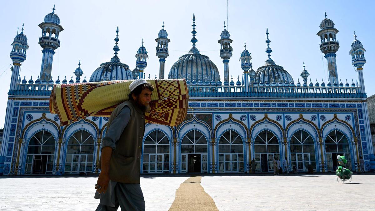 A Pakistani Muslim carries a prayer mat rolled up on his shoulder in preparation for prayers on May 6, 2019. (AFP / File)