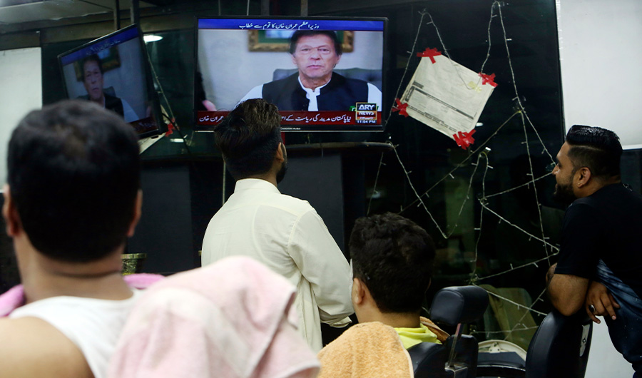 People watch a televised speech of Pakistan's Prime Minister Imran Khan, in Karachi, Pakistan, Wednesday, June 12, 2019. Khan vowed to ensure that former President Asif Ali Zardari and ex-Premier Nawaz Sharif are held accountable for wrongdoing, accusing them of being responsible for the financial crisis currently faced by the Islamic nation. (AP)