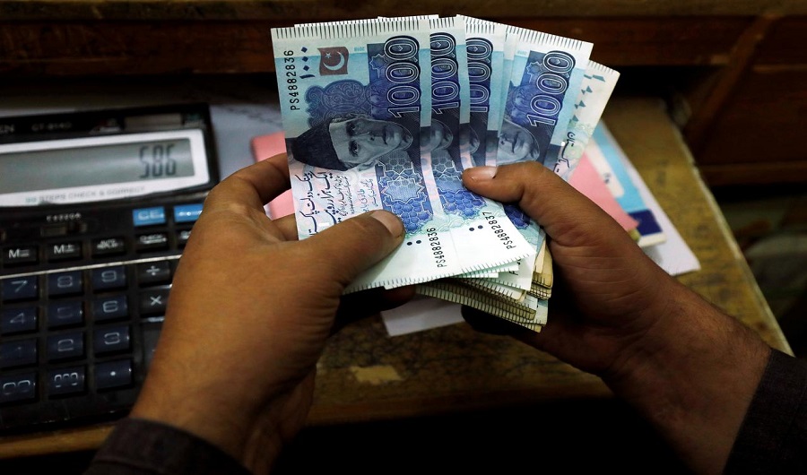 A trader counts Pakistani rupee notes at a currency exchange booth in Peshawar, Pakistan December 3, 2018. (REUTERS)