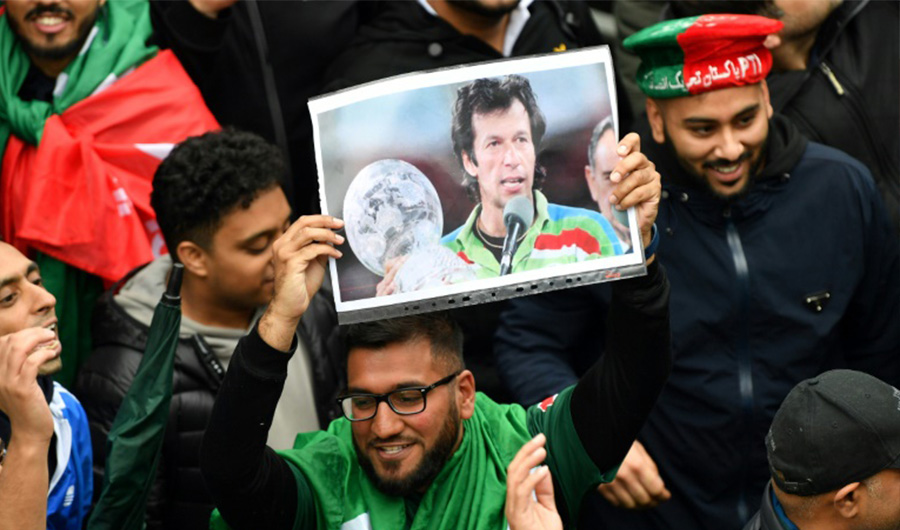 A Pakistan fan in England holds a picture of Prime Minister Imran Khan showing him as skipper of the team that won the 1992 World Cup – AFP
