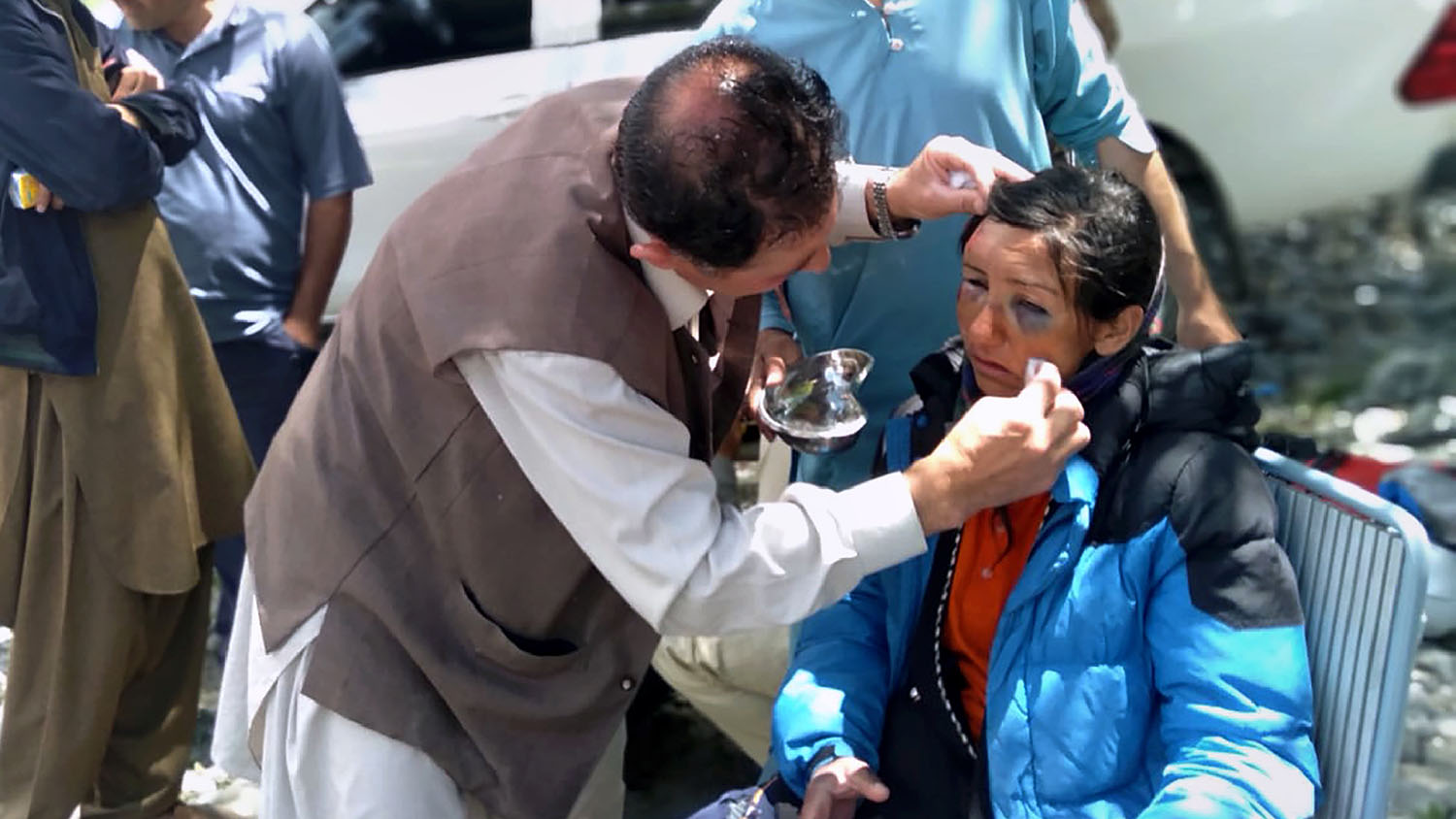In this photo provided by Gilgit Baltistan regional police department, mountaineers receive initial treatment following her rescue, at a helipad in the town of Imit, Ghizer district of Gilgit Balistan region, Pakistan, Tuesday, June 18, 2019. (Gilgit Baltistan regional police department via AP)