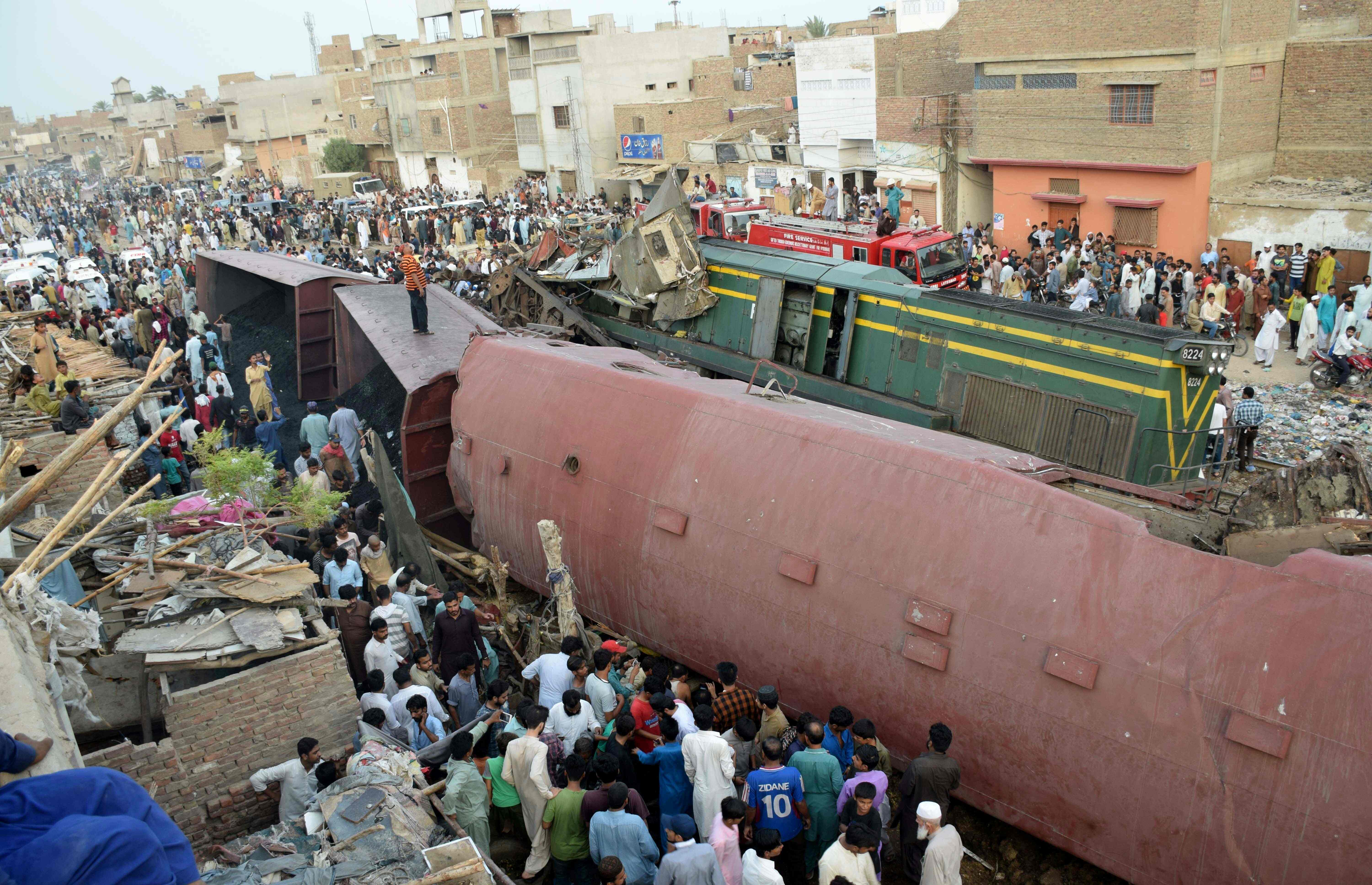 Pakistani onlookers gather around damaged carriages after a passenger train rammed into a goods train in Hyderabad on June 20, 2019. At least three people were killed and several others injured when the two trains collided in Pakistan’s southern Sindh province, officials said. (AFP)
