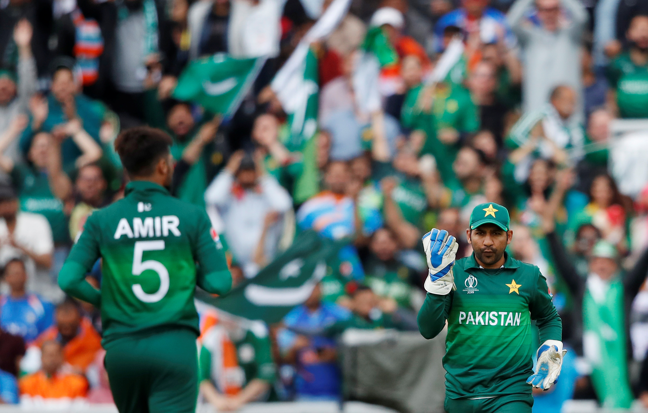 Pakistan's Mohammad Amir and Sarfaraz Ahmed celebrate the wicket of India's MS Dhoni during ICC Cricket World Cup match at Old Trafford, Manchester, Britain - June 16, 2019. (Reuters)