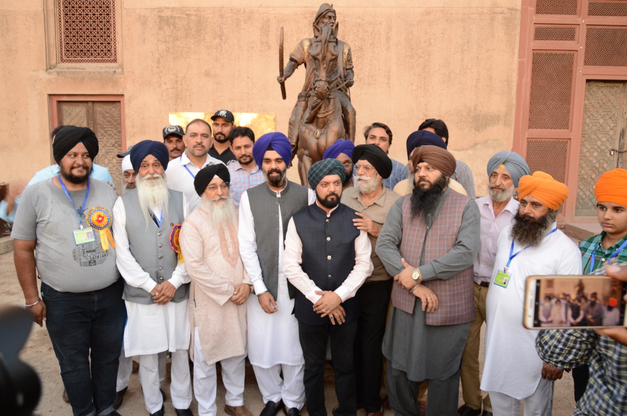 Members of Sikh community from Pakistan and India pose for a picture in front of the newly installed statue of Maharaja Ranjit Singh at the Lahore Fort on June 27, 2019. (AN Photo)