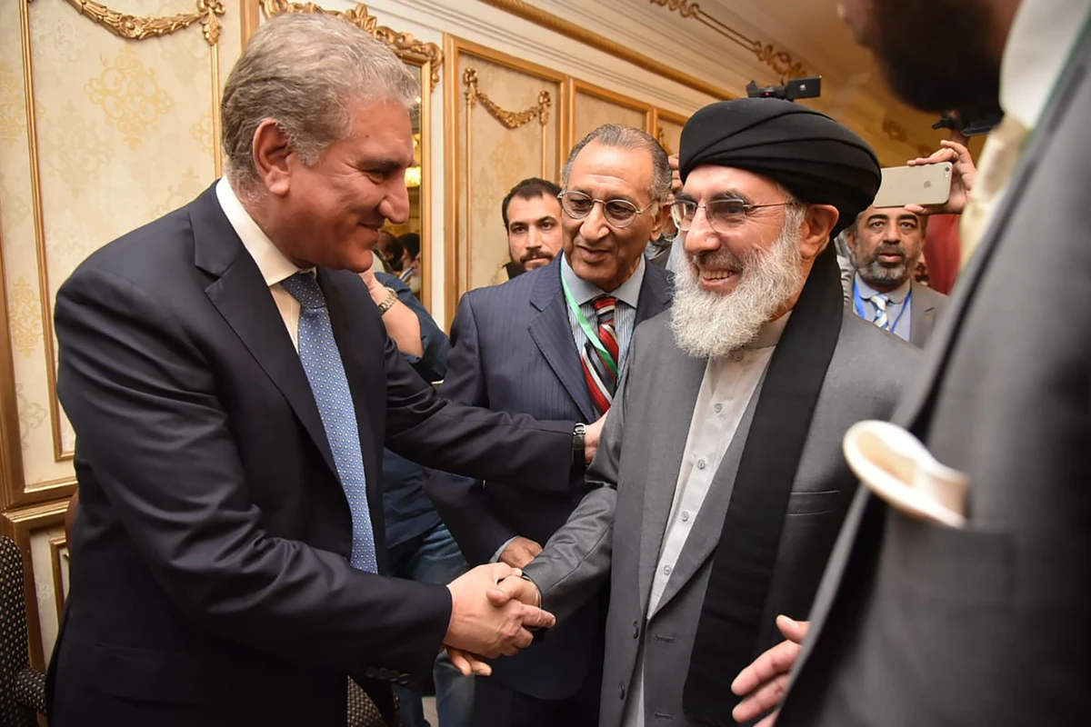 Pakistan's Foreign Minister Shah Mahmood Qureshi (L) shakes hands with Afghan warlord Gulbuddin Hekmatyar, before a peace conference, in Bhurban, Pakistan Saturday, June 22, 2019. (AFP PHOTO / PAKISTAN FOREIGN MINISTERY)