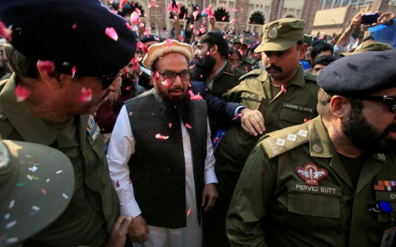 Hafiz Saeed is showered with flower petals as he walks to court before a Pakistani court ordered his release from house arrest in Lahore, Pakistan Nov. 22, 2017. (REUTERS)