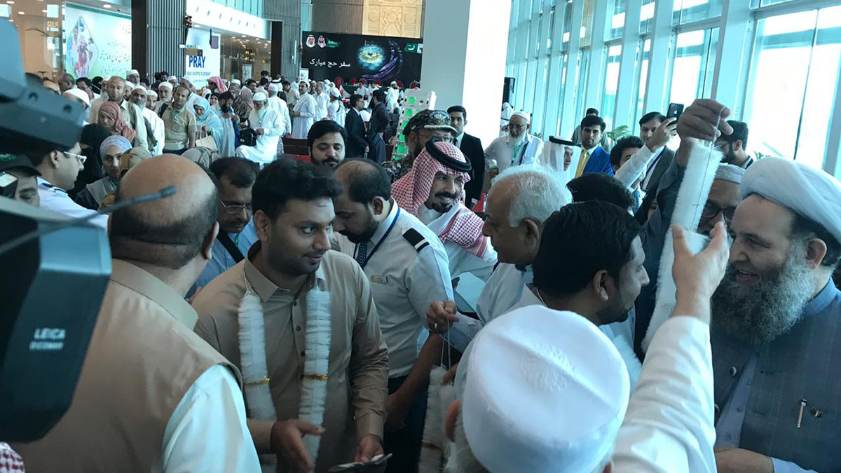 Pakistani Federal Minister for Religious Affairs Pir Noorul Haq Qadri and Minister for Aviation Ghulam Sarwar Khan welcome Hajj pilgrims at the Islamabad International Airport on July 4, 2019. (Pakistani ministry of religious affairs handout)