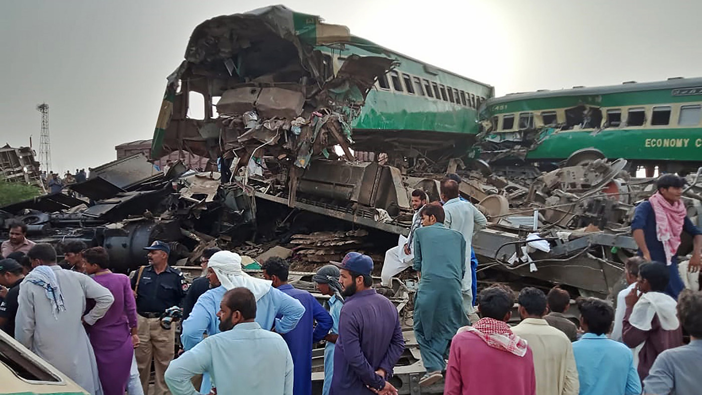 Pakistani local residents gather around the wreckage of carriages at the site where two trains collided in Rahim Yar Khan district of Punjab province on July 11, 2019. (AFP)