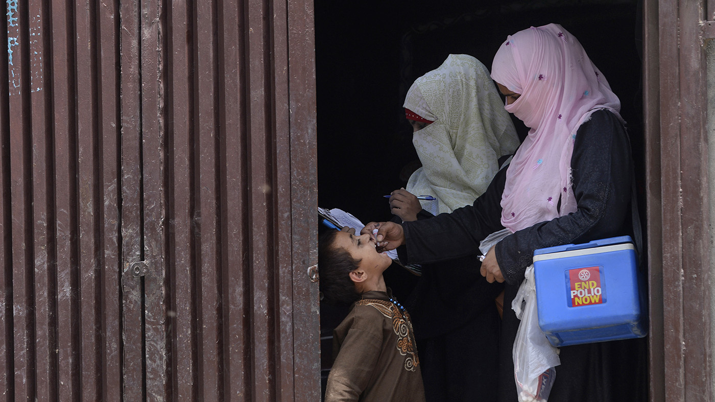 Pakistani health workers administer polio vaccine drops to an Afghan refugee child during a polio vaccination campaign in Lahore on June 19, 2019. (AFP/File)