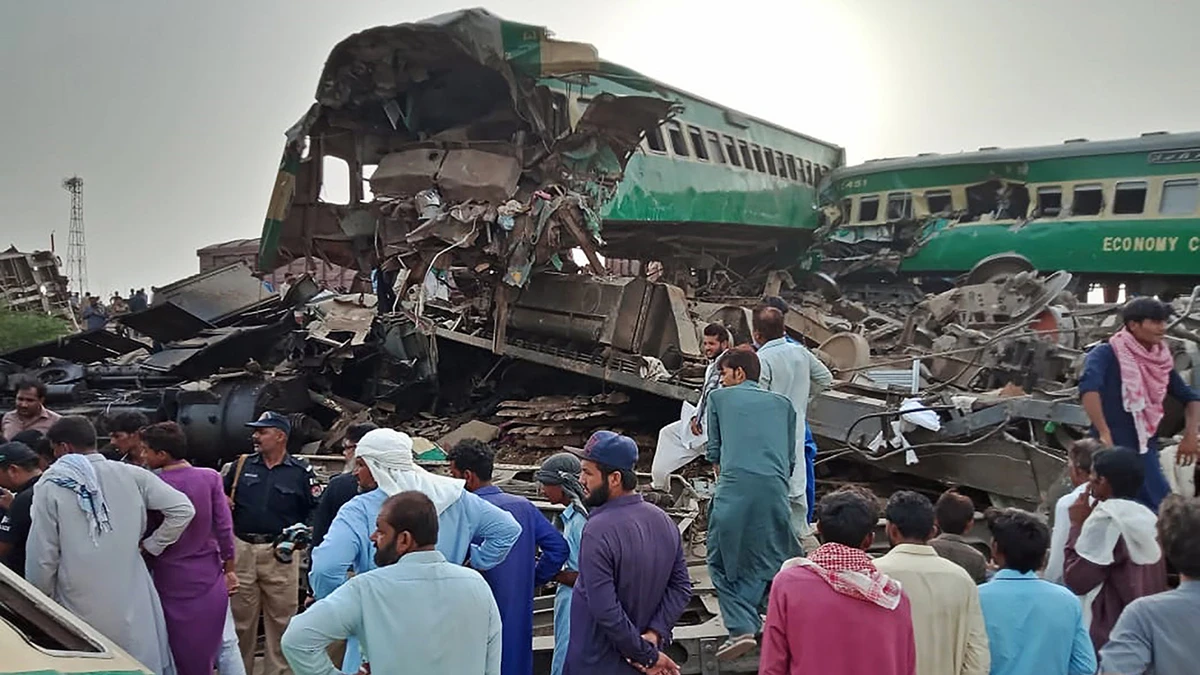 Pakistani local residents gather around the wreckage of carriages at the site where two trains collided in Rahim Yar Khan district of Punjab province on July 11, 2019. (AFP)