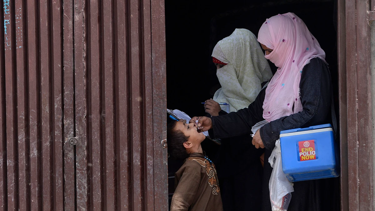Pakistani health workers administer polio vaccine drops to an Afghan refugee child during a polio vaccination campaign in Lahore on June 19, 2019. (AFP/File)