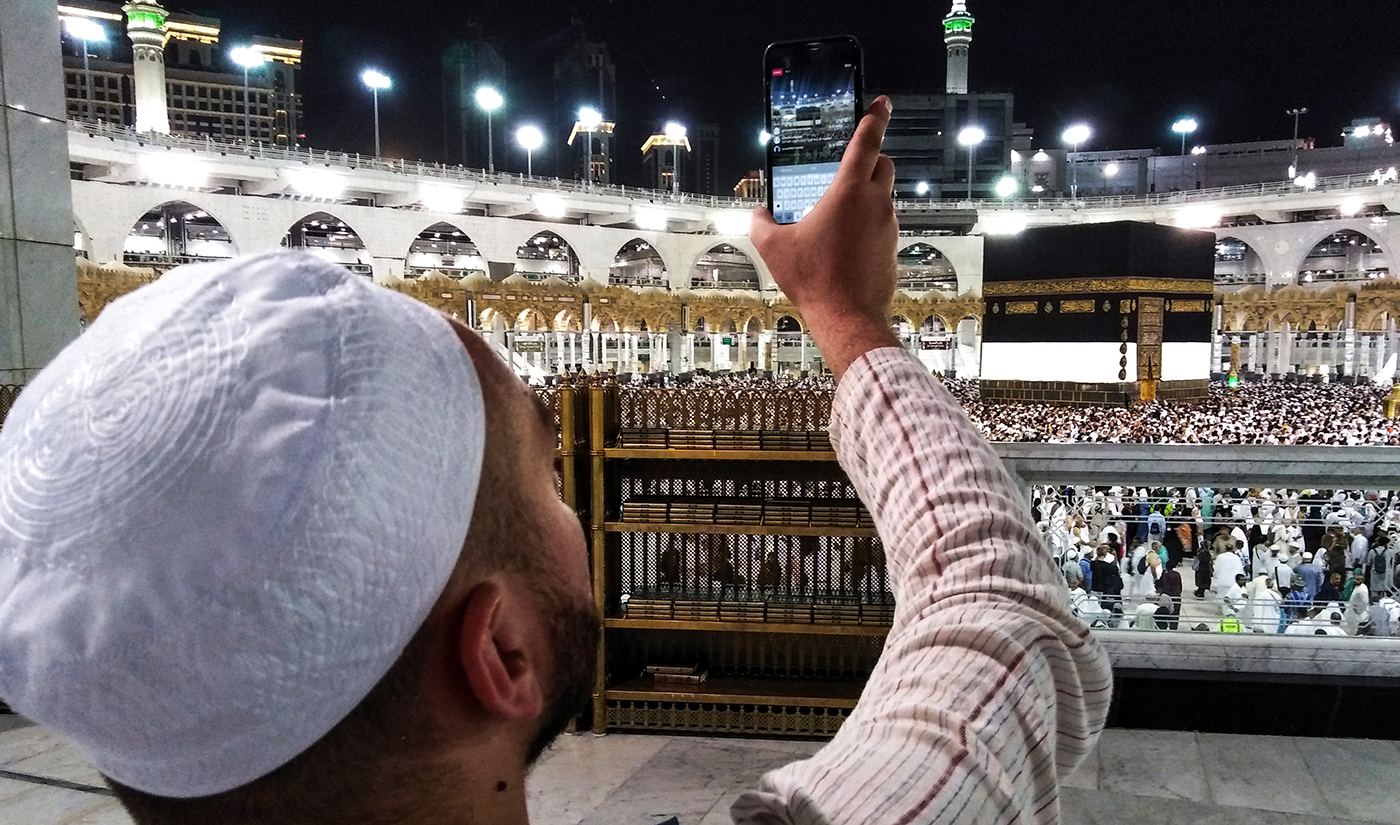 In this file photo, a Muslim worshipper uses his cell phone to Livestream film others circumambulating around the Kaaba at the Grand Mosque in Saudi Arabia’s holy city of Makkah on Aug. 17, 2018. (AFP)