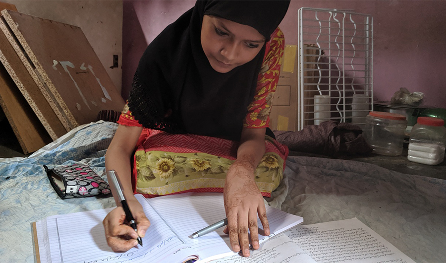 Ume Hani, a thirteen year old girl from Karachi’s Bengali community, is writing a historical essay on Pakistan as part of her eighth grade homework at her home in Bengali Para, Karachi. July 24, 2019 (AN Photo)