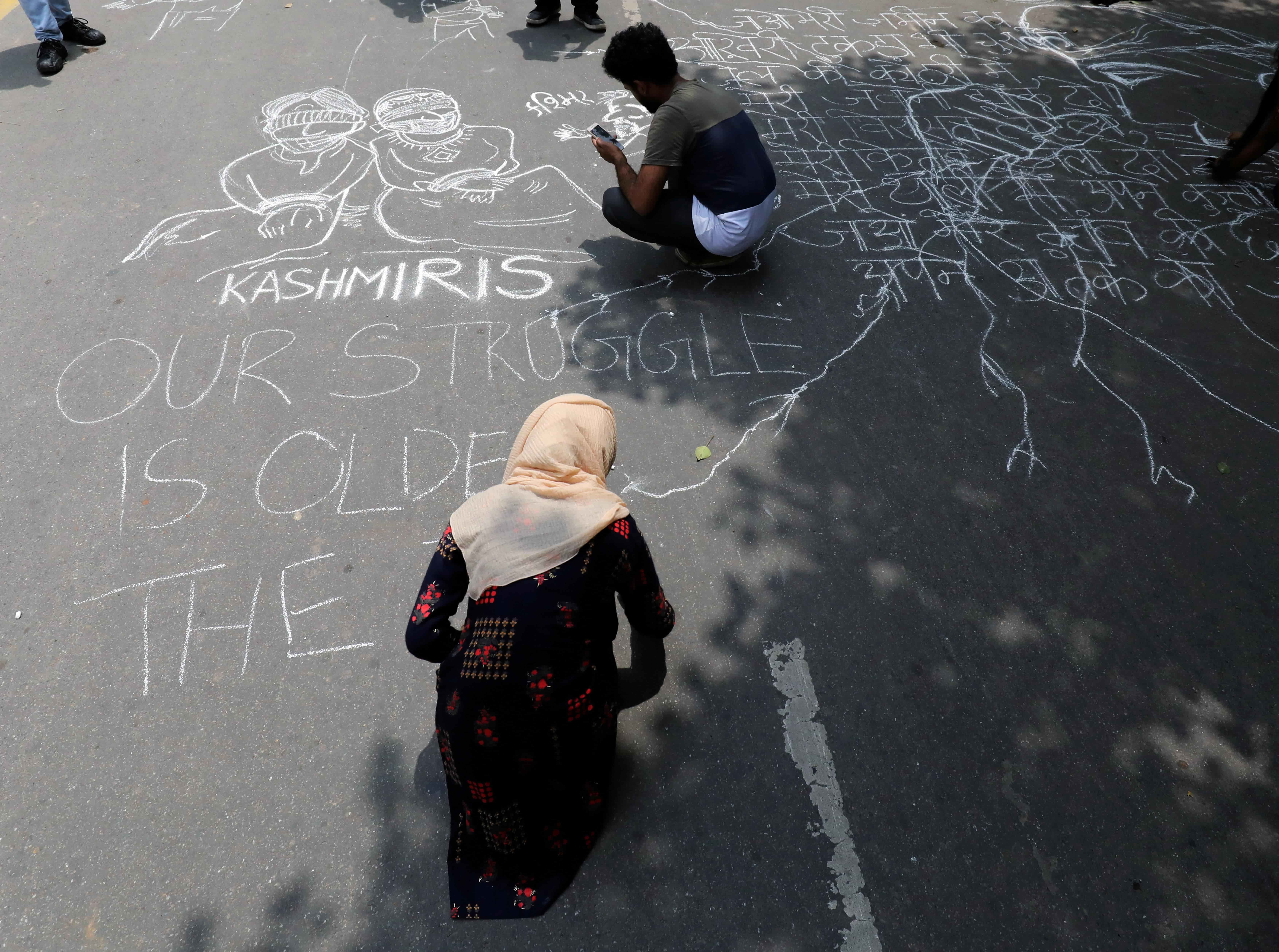People draw and write messages on a road during a protest against the scrapping of the special constitutional status for Kashmir by the government, in New Delhi, India, August 7, 2019. (Reuters)