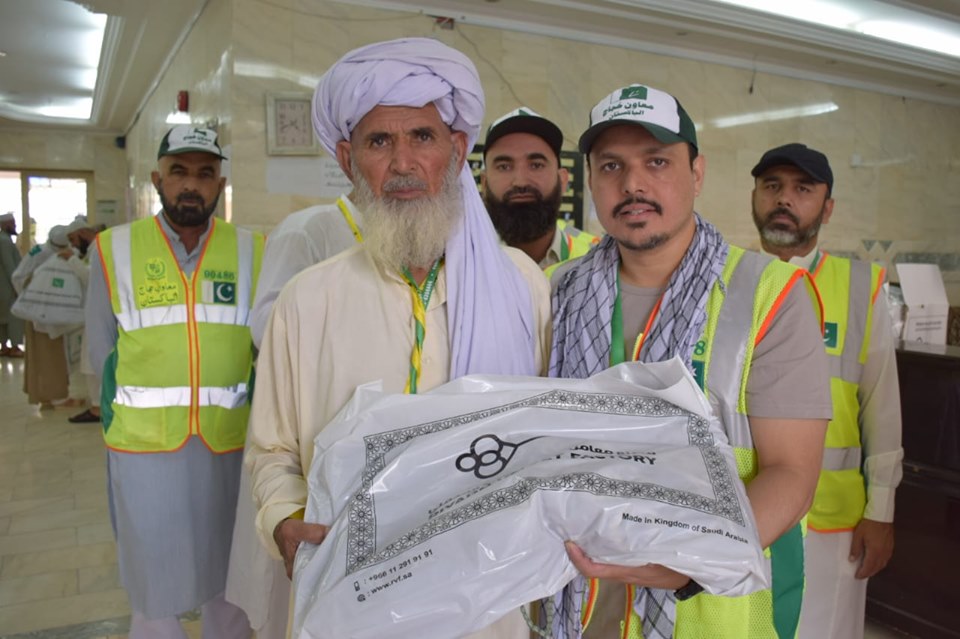 In this undated picture, a group of volunteers pose with a Pakistani pilgrim who received some items of necessity from the Pakistani Hajj Mission. The country's religious ministry told Arab News on Friday it had deployed more than 4,000 volunteers in the field to facilitate Pakistani pilgrims during Hajj 2019. (Courtesy Ministry of Religious Affairs)