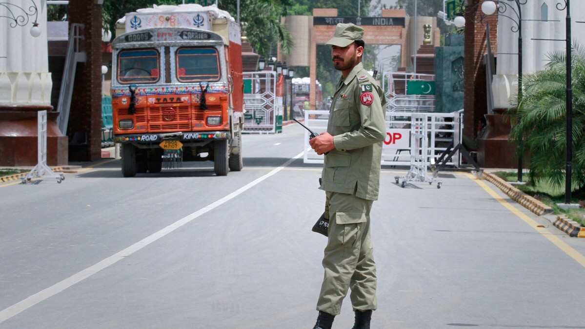 In this undated file photo, a Pakistani paramilitary soldier stands guard as a truck carrying wheat crosses into Pakistan from India at the Wagah border. (Reuters)