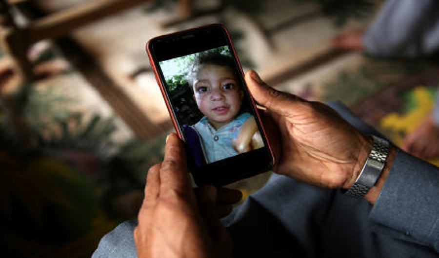 Mobile phone displaying picture of a boy who was killed after a cluster bomb that looked like a toy exploded in his hands at home in village Jabri, in Neelum Valley (Reuters)