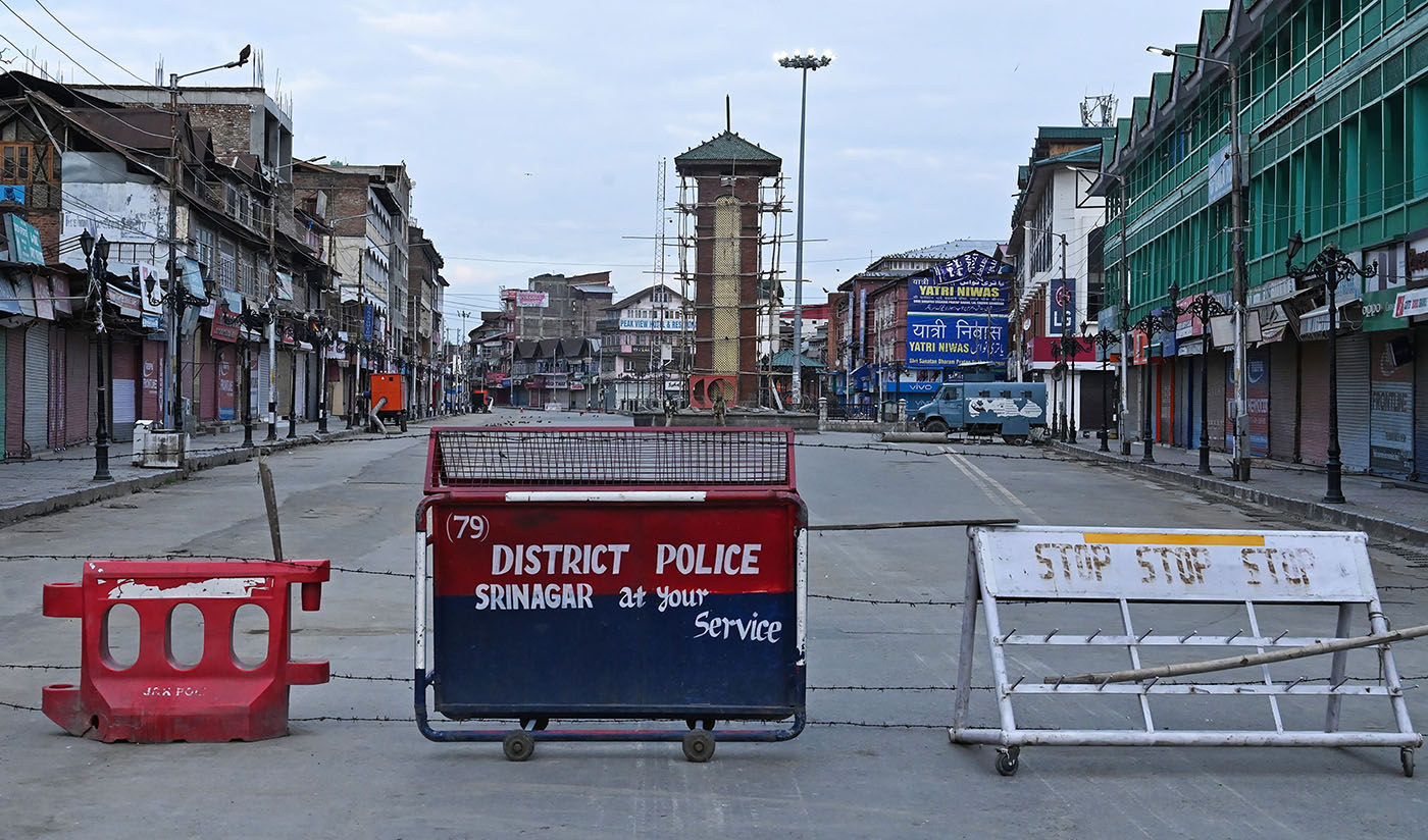 Security personnel (back) stand guard a street under the clock tower at Lalchowk during a lockdown in Srinagar on Aug. 12, 2019. (AFP)