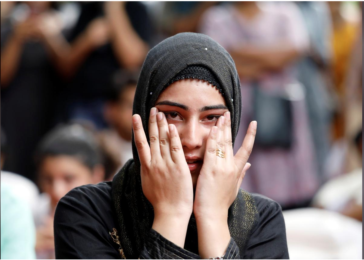 A Kashmiri woman wipes her tears while listening to a story of another Kashmiri man at a function where fellow compatriots gathered to observe Eid al-Adha, away from their home in Kashmir, where Indian government has imposed restrictions after scrapping the special constitutional status, in New Delhi, India, August 12, 2019. (REUTERS)