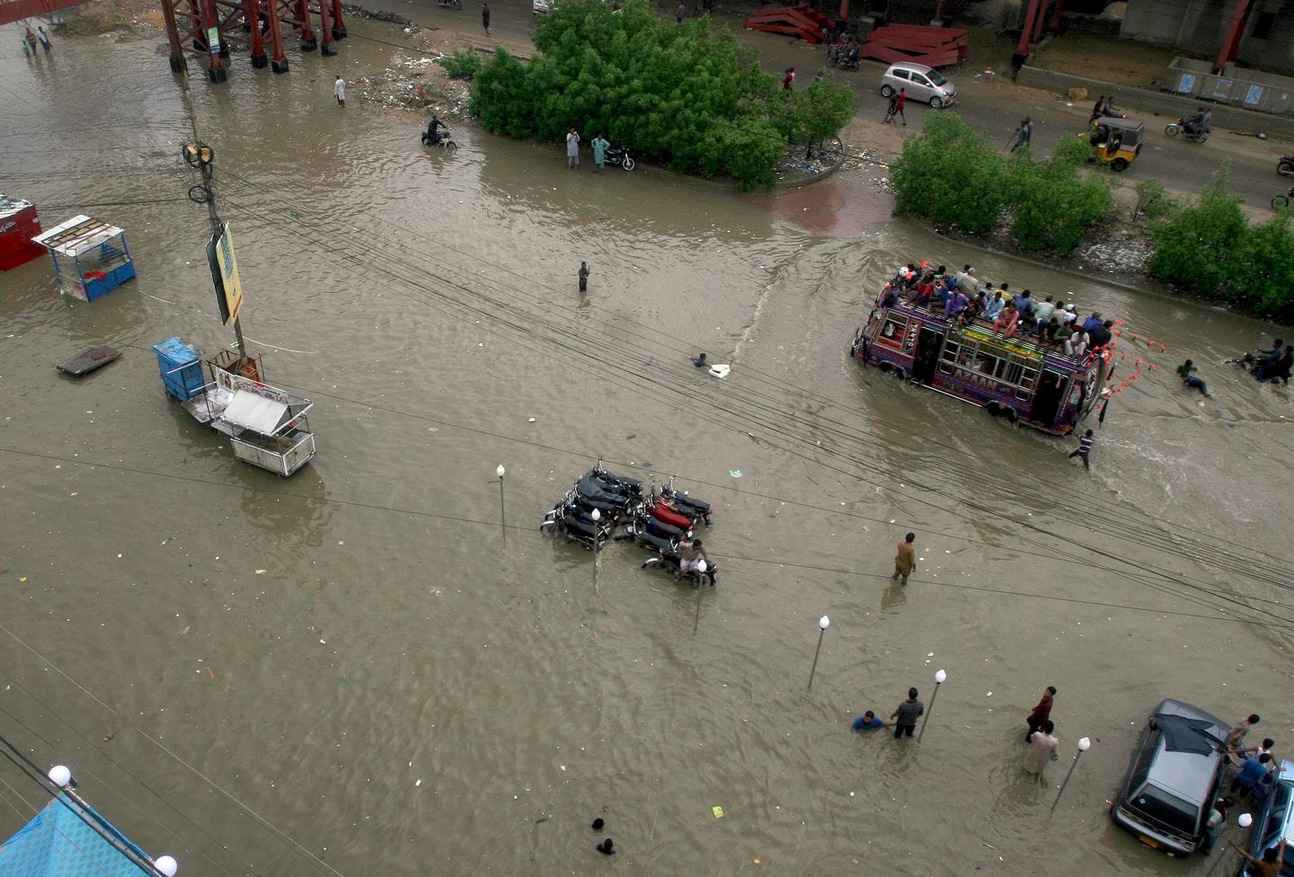 An overloaded bus drives through a flooded road caused by heavy monsoon rains, in Karachi, Pakistan, Sunday, Aug. 11, 2019. Monsoon rains have inundated much of Pakistan, leaving large parts of the southern city of Karachi underwater and causing some deaths. (Fareed Khan/AP)