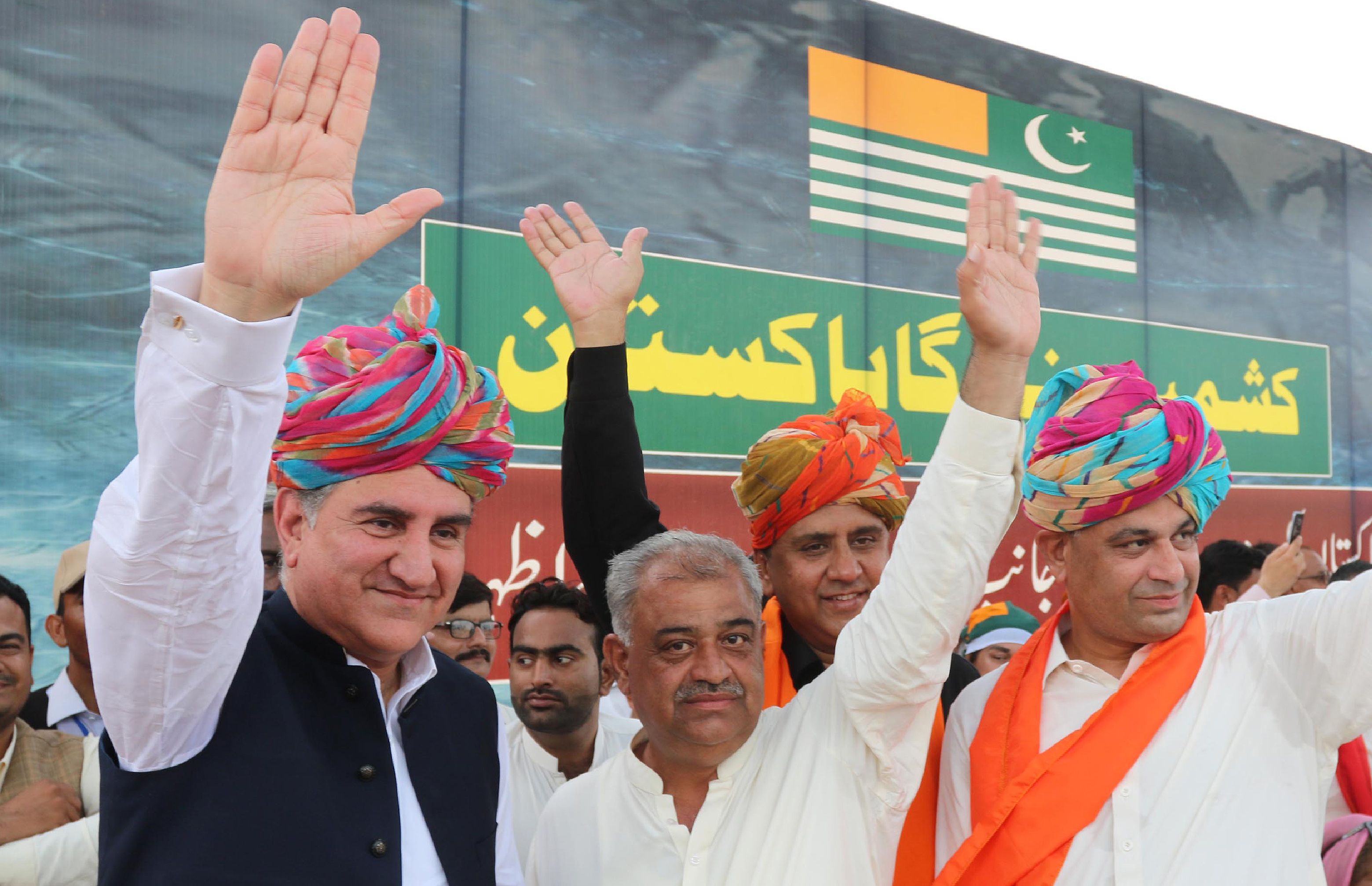 Pakistani Foreign Minister Shah Mehmood Qureshi (L) waves to supporters on the Kashmir solidarity gathering organised by Hindu community near Shiv Mandir, in Umerkot on August 31, 2019. (AFP)