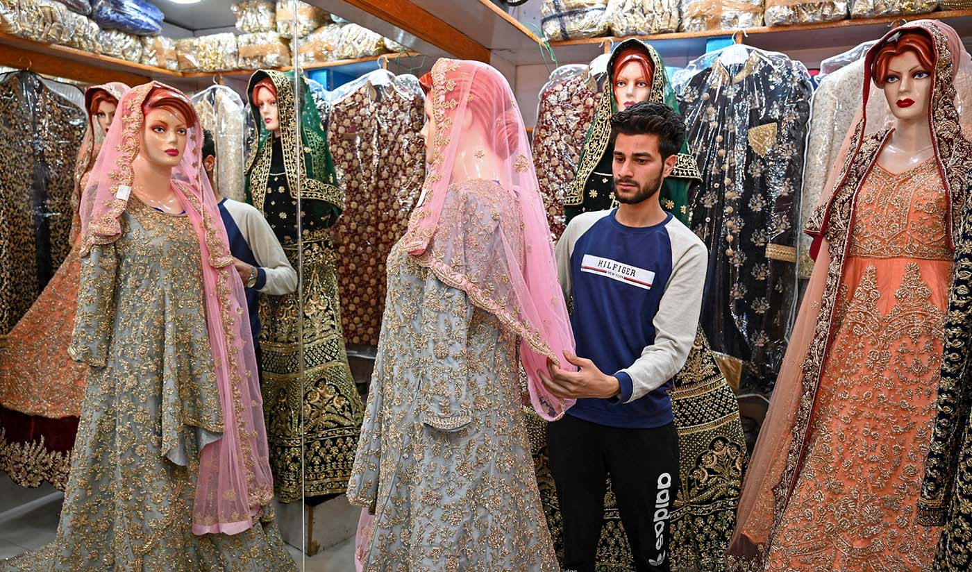 In this file picture taken on June 3, 2019, a Kashmiri shopkeeper displays a wedding dress at a market ahead of the Muslim festival of Eid Al-Fitr in Srinagar. (AFP)