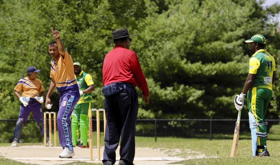 Image Caption : In this Sunday, Aug. 11, 2019 photo, Staten Island Cricket Club bowler gestures during a match against Pioneer Cricket Club in the Brooklyn borough of New York. Despite their familiar languages, Staten Island CC, unlike most other teams on the New York City cricket circuit, does not have a dominant religion or ethnicity. (AP Photo)