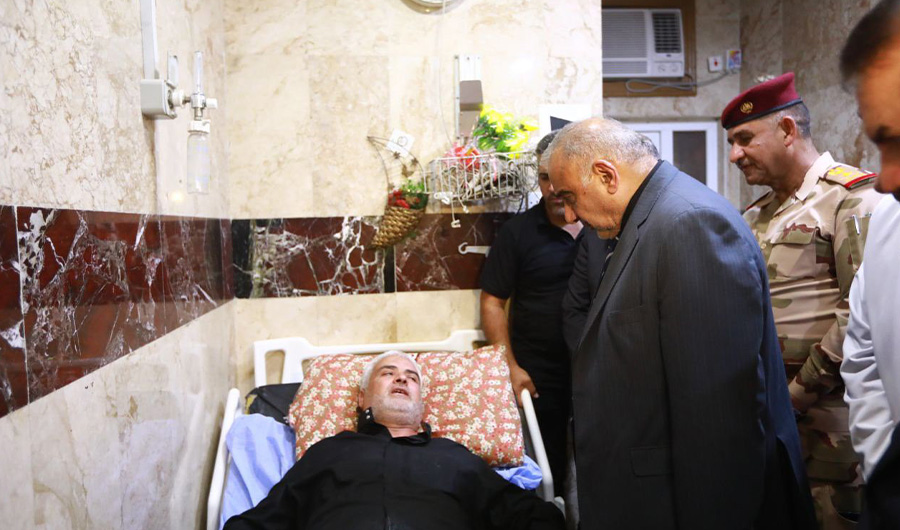 A handout image released by the press office of Iraqi Prime Minister Adel Abdel Mahdi on September 10, 2019 shows him visiting an injured person at the hospital in Baghdad, Iraq. More than 30 pilgrims were killed and dozens injured on September 10, 2019 in a stampede in the Iraqi city of Karbala. (AFP)