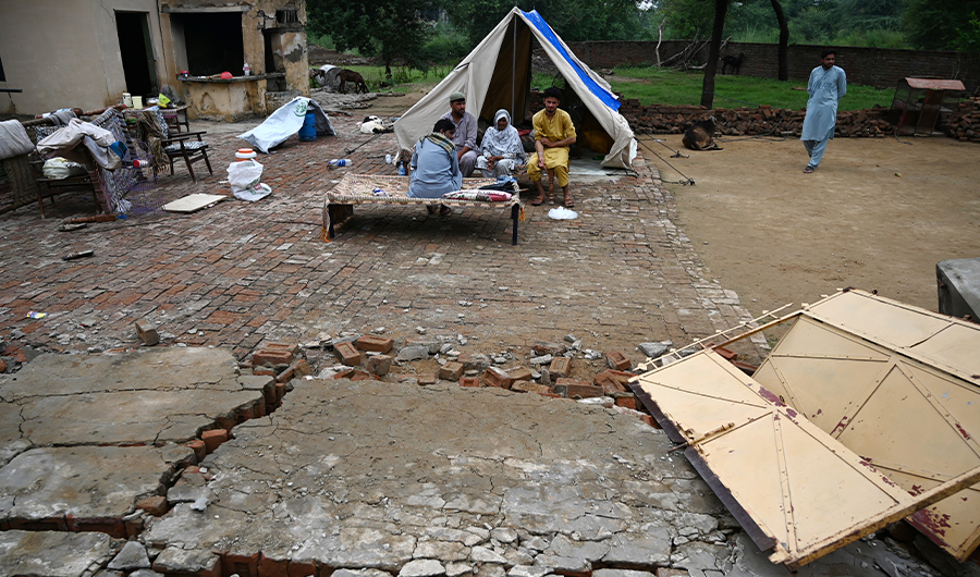 Pakistani survivors sit by a tent outside their damaged home in an earthquake-hit area on the outskirts of Mirpur in Pakistan-controlled Kashmir on September 26, 2019. Rescuers battled along badly damaged roads and combed through toppled buildings to reach victims of an earthquake that killed at least 38 people and injured hundreds more in northeast Pakistan.(AFP)