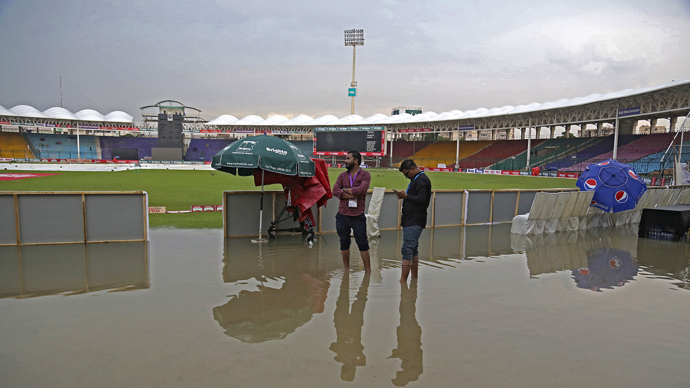 Officials stand at the National Stadium after rain in Karachi on Sept. 27, 219. (AP)