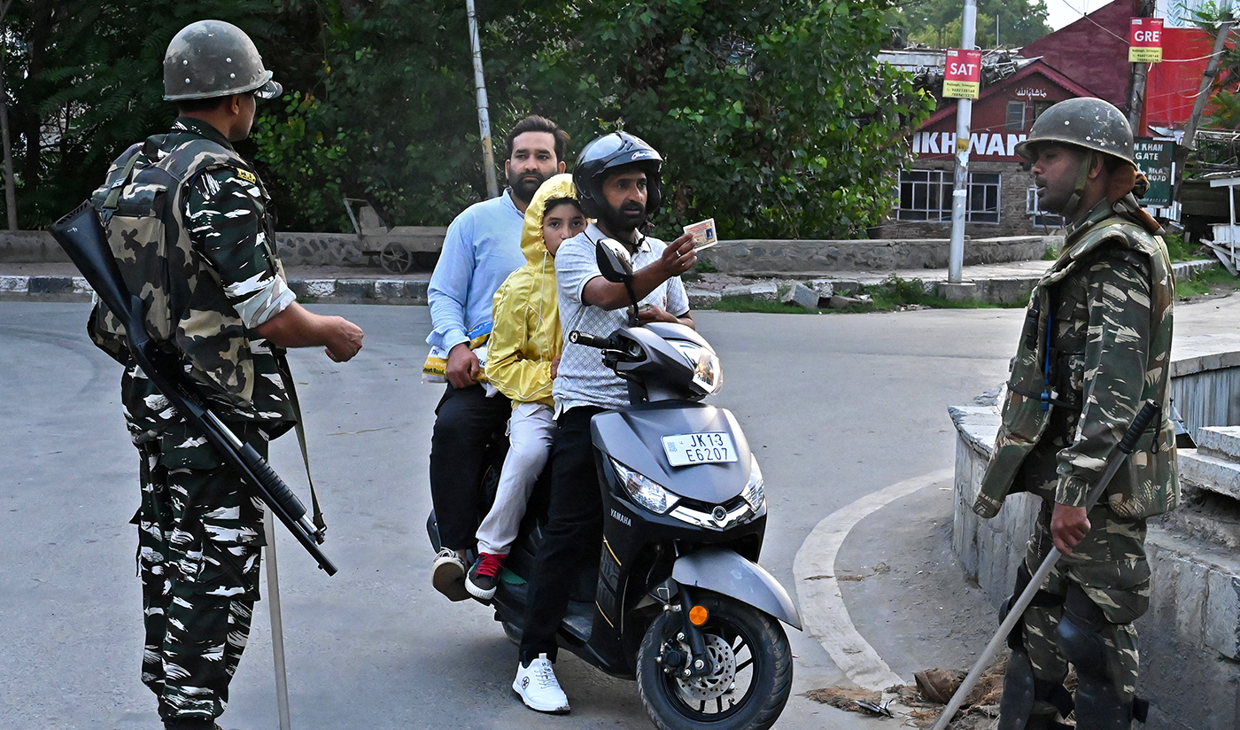 A motorist shows his identity card to a security personnel after being stopped for questioning at a roadblock during a lockdown in Srinagar on Aug. 12, 2019. (AFP/File)