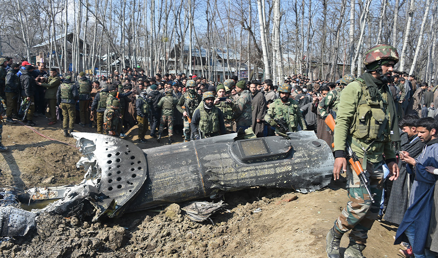In this file photo taken on February 27, 2019 Indian soldiers and Kashmiri onlookers stand near the remains of an Indian Air Force helicopter after it crashed in Budgam district, outside Srinagar. (AFP)