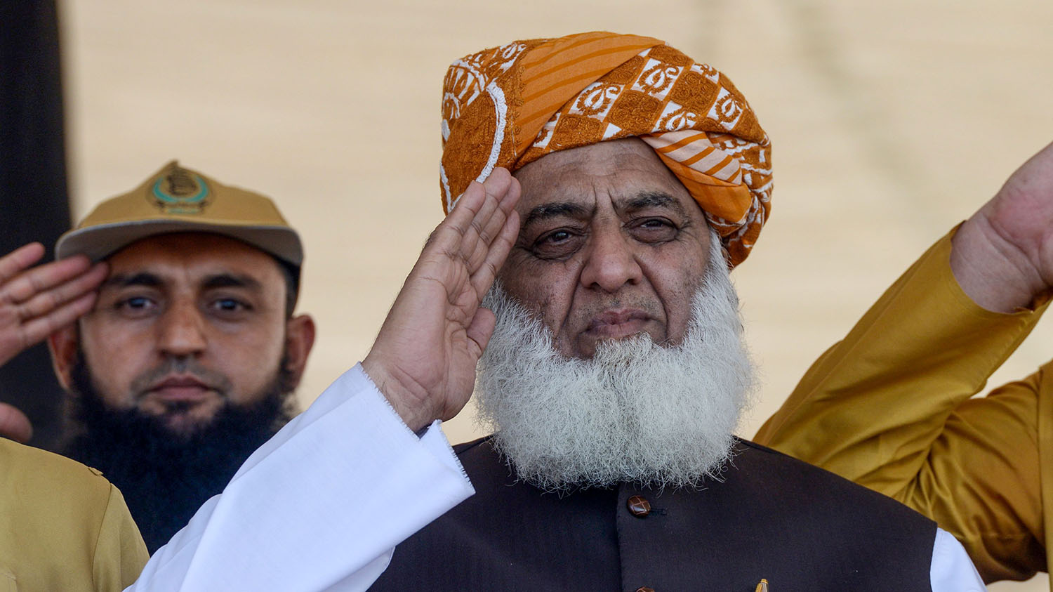 Jamiat Ulema-e Islam Fazal (JUI-F) chief, Maulana Fazal-ur-Rehman, center, salutes as he watches the preparations of an 'Azadi' (freedom) march in Peshawar on Oct. 13, 2019. (AFP)