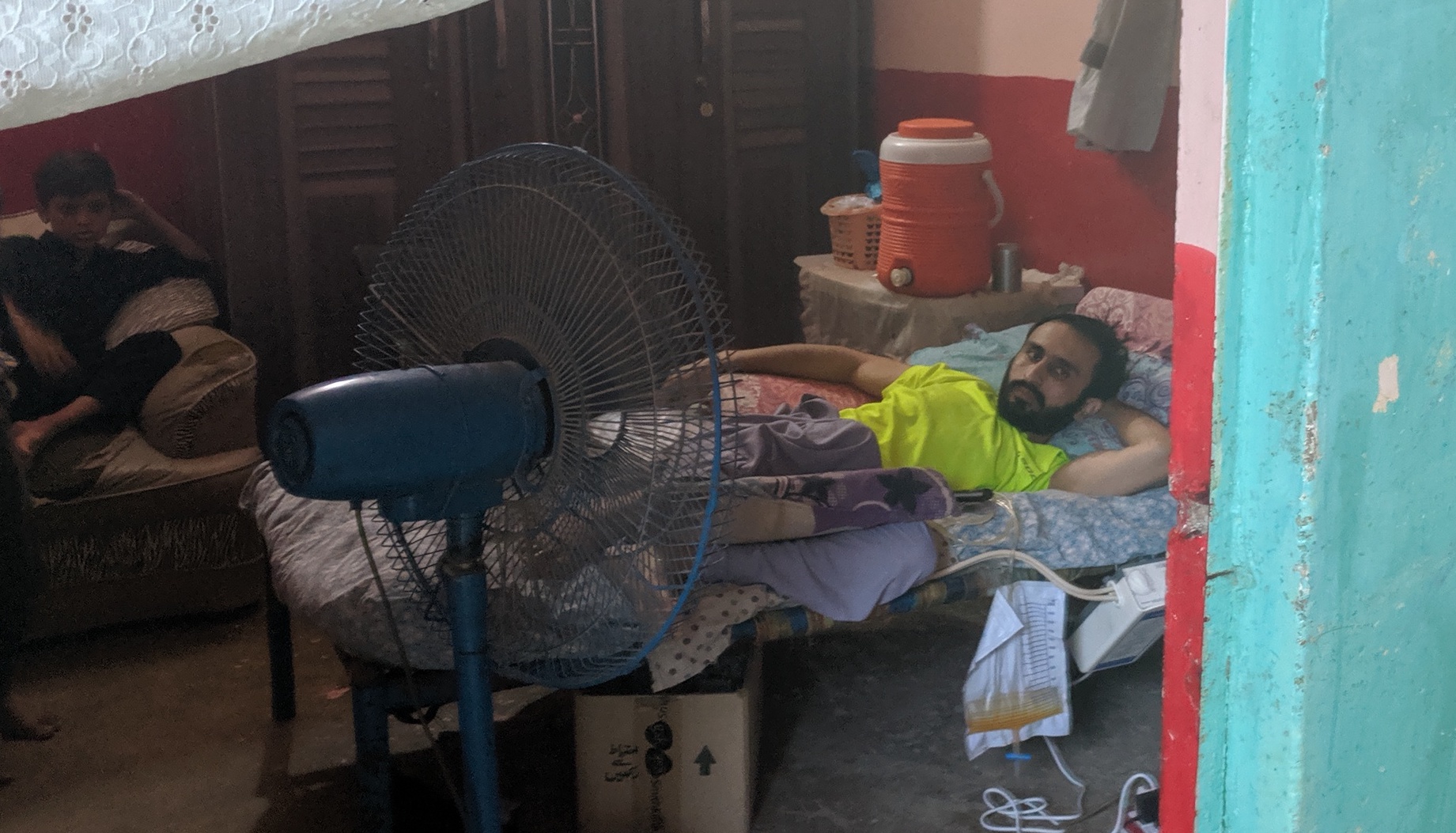 Irshad Hussain, 32 years old who got disabled while guarding former Prime Minister Benazir Bhutto from attack on her homecoming on Oct 18, 2007, is laying on his Charpai at his residence at the lower-class Pehlwan Goth neighbourhood of Karachi on Oct 18, 2019 (AN Photo)