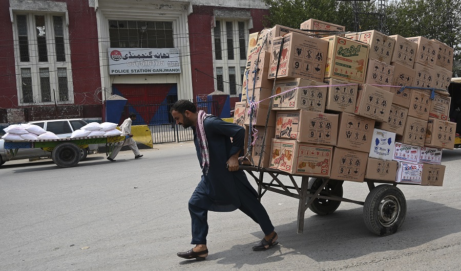 In this picture taken on July 22, 2019, a labourer pulls a loaded cart along a street at a market in Rawalpindi. (AFP)