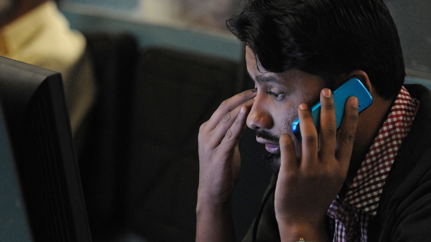 In this file photo, a Pakistani stockbroker talks on his mobile phone while watching share prices on a monitor during a trading session at the Karachi Stock Exchange (KSE) in Karachi on Jan. 2, 2013. (AFP/file)